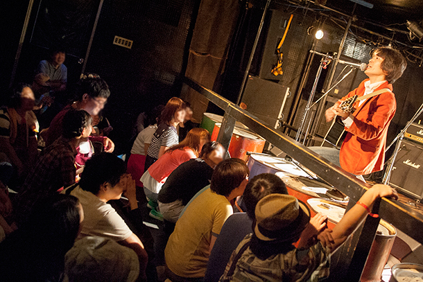 「観客を全員座らせ、自分も座ってコンドームについて歌う松尾よういちろう（vo）」46枚目/63